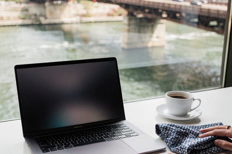 A desk with a laptop and a folded indigo blueprint cloth